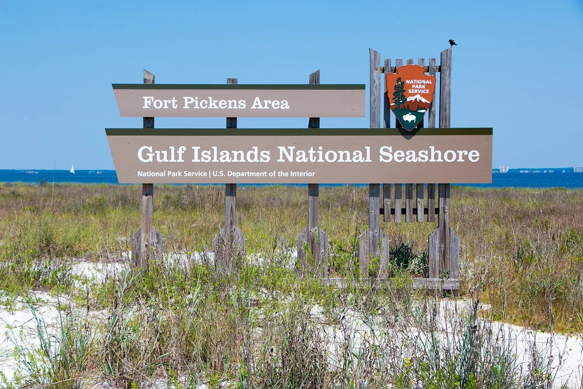 Fort Pickens Area entrance sign for Gulf Islands National Seashore, with dunes and sea oats